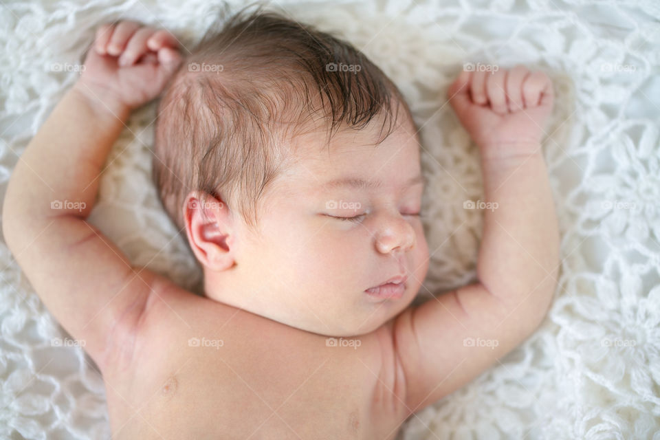 High angle view of a baby sleeping on bed