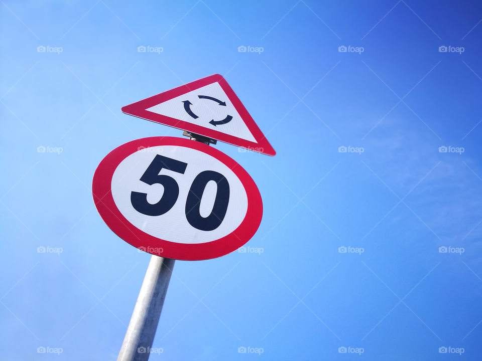 Maximum speed limit sign and roundabout sign. Traffic sign.