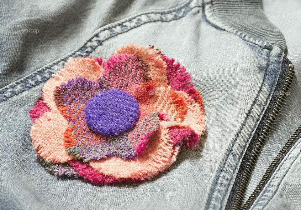 Tartan flower brooch on denim jacket.