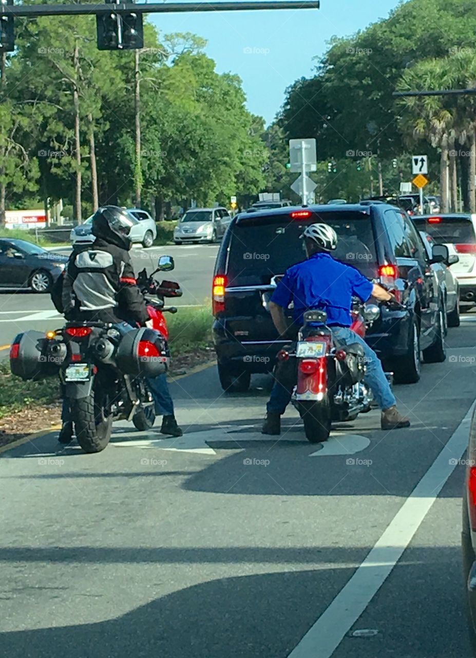 Two motorcycles waiting in traffic at lights!