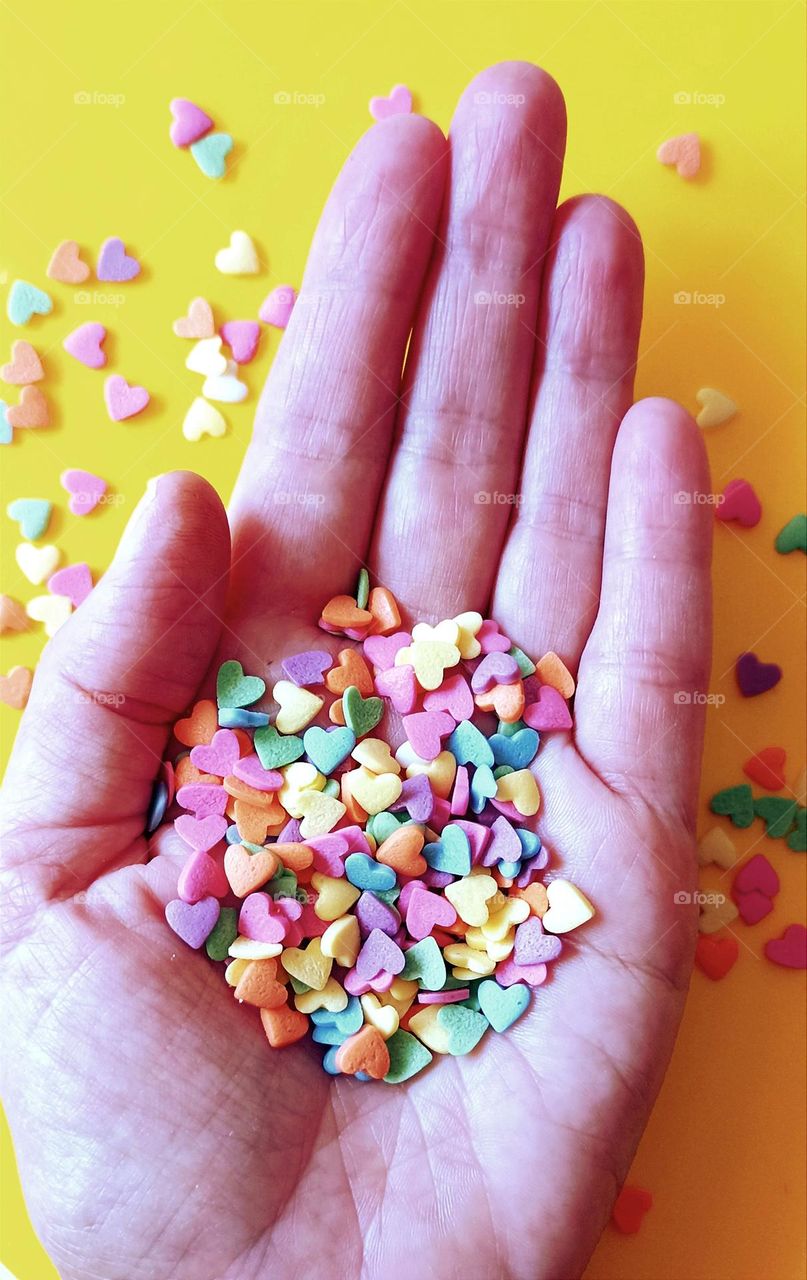 colour hearts in the hand top view, love