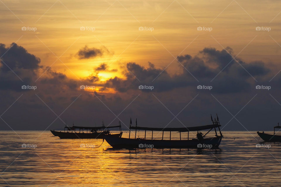 Longboats on the water at sunrise from the island of Koh Rong in Cambodia 