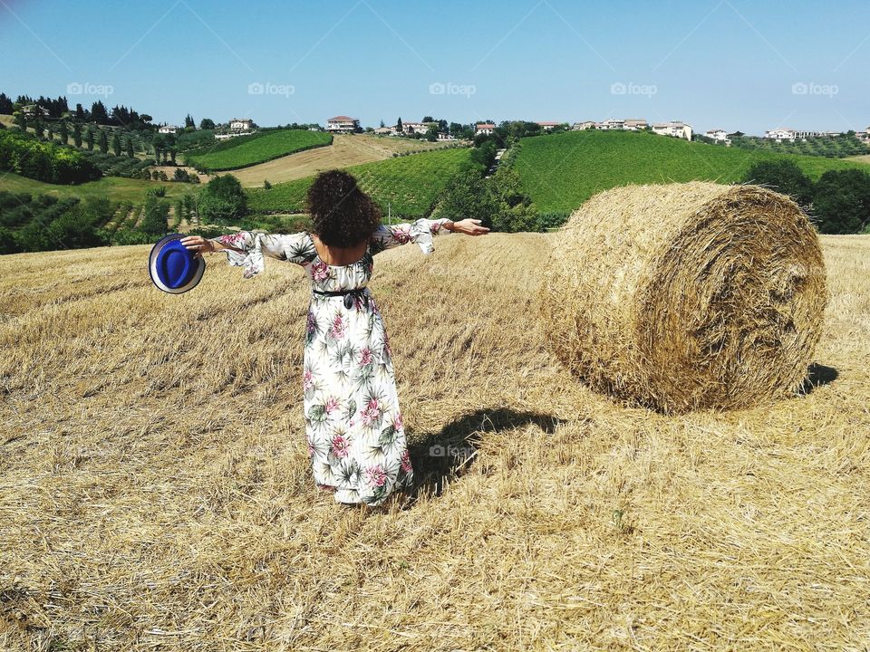 Woman with her arms outstretched enjoys the view of the countryside