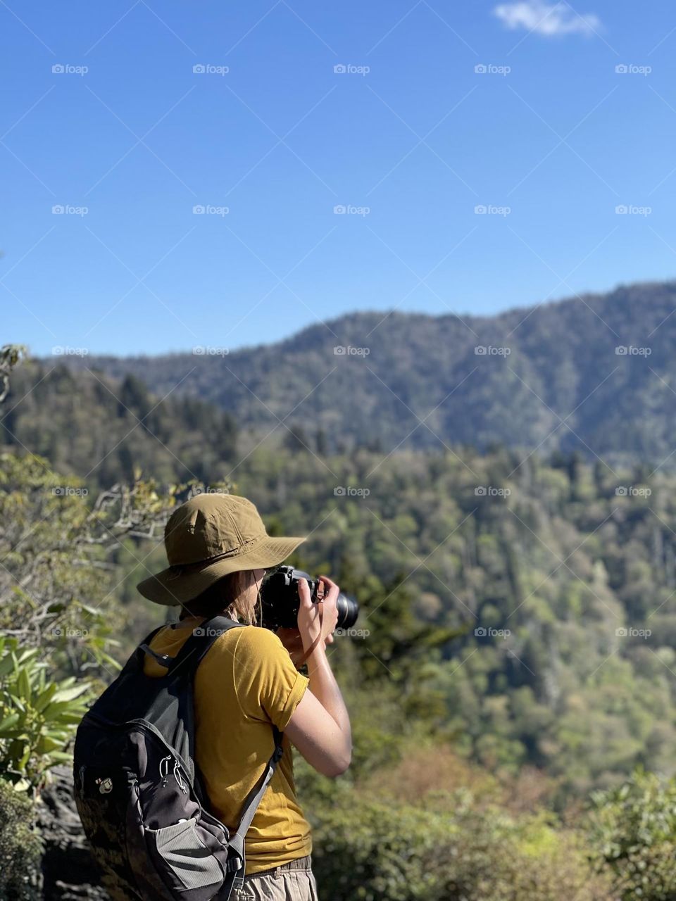 Woman on a mountain taking pictures of the Great Smoky Mountains 