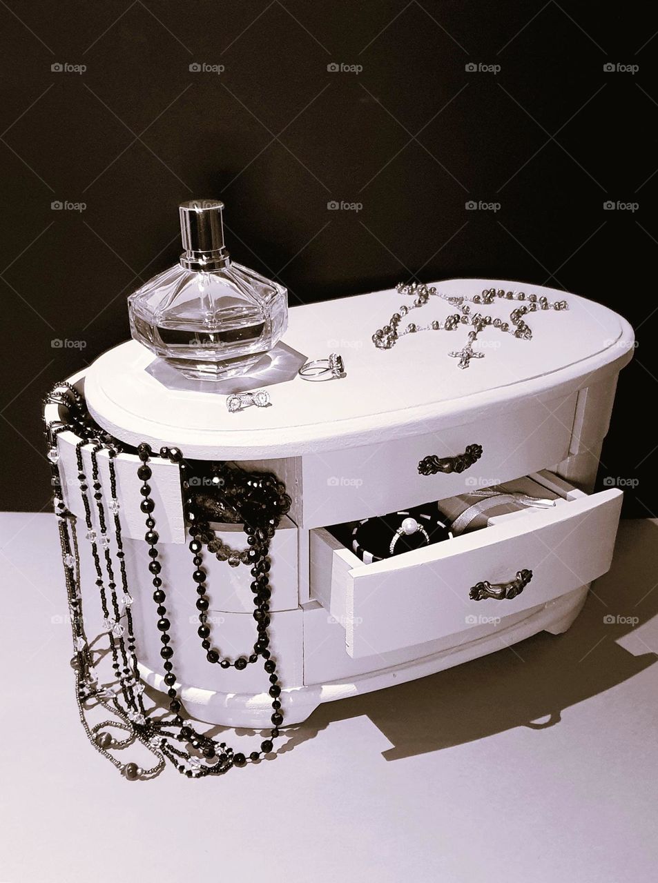 Sepia shot of a vintage jewellery box, perfum bottle, rosary and jewellery in and out of the box