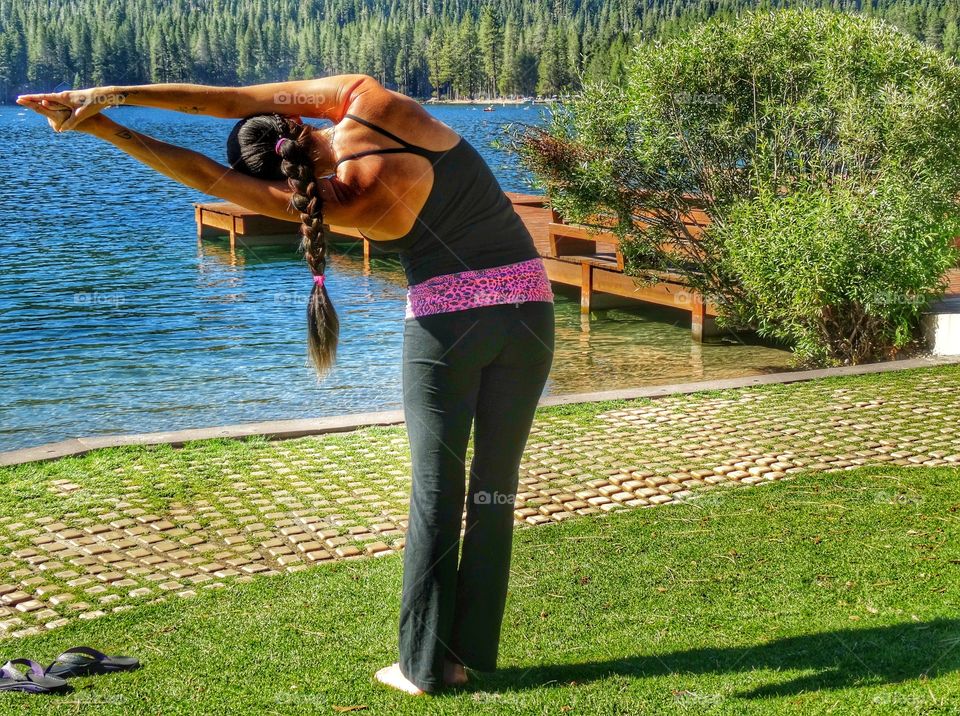 Woman Doing Yoga Near A Mountain Lake