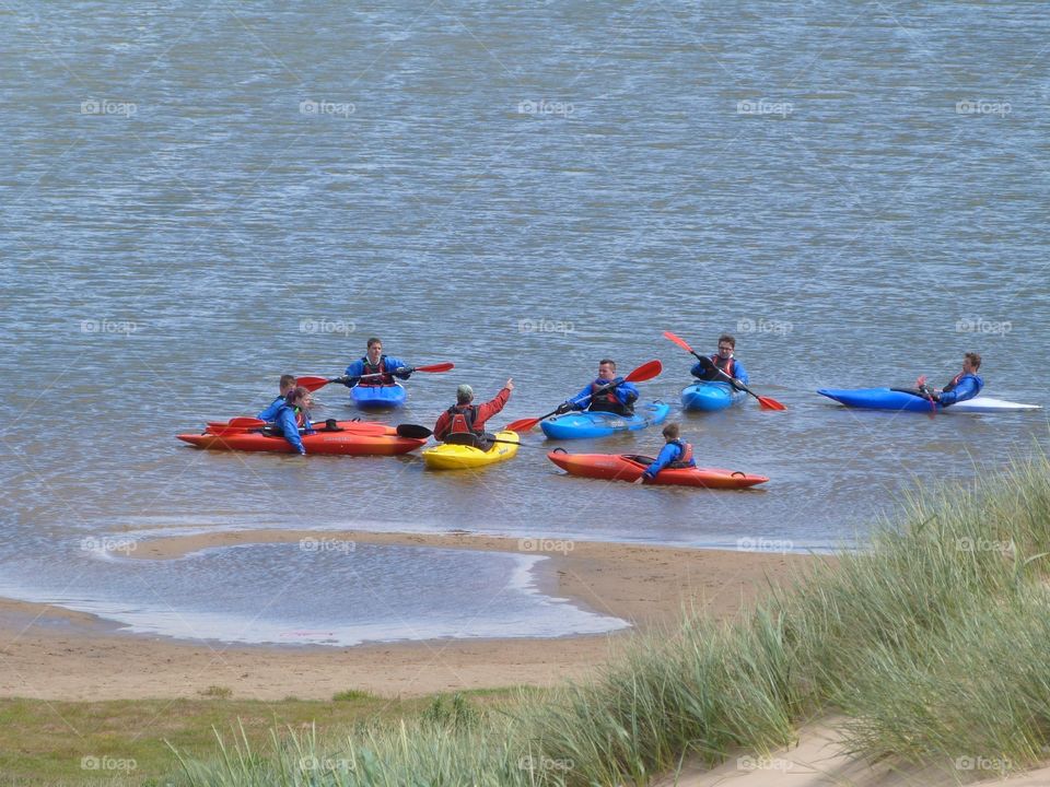Group of people learning to canoe 
