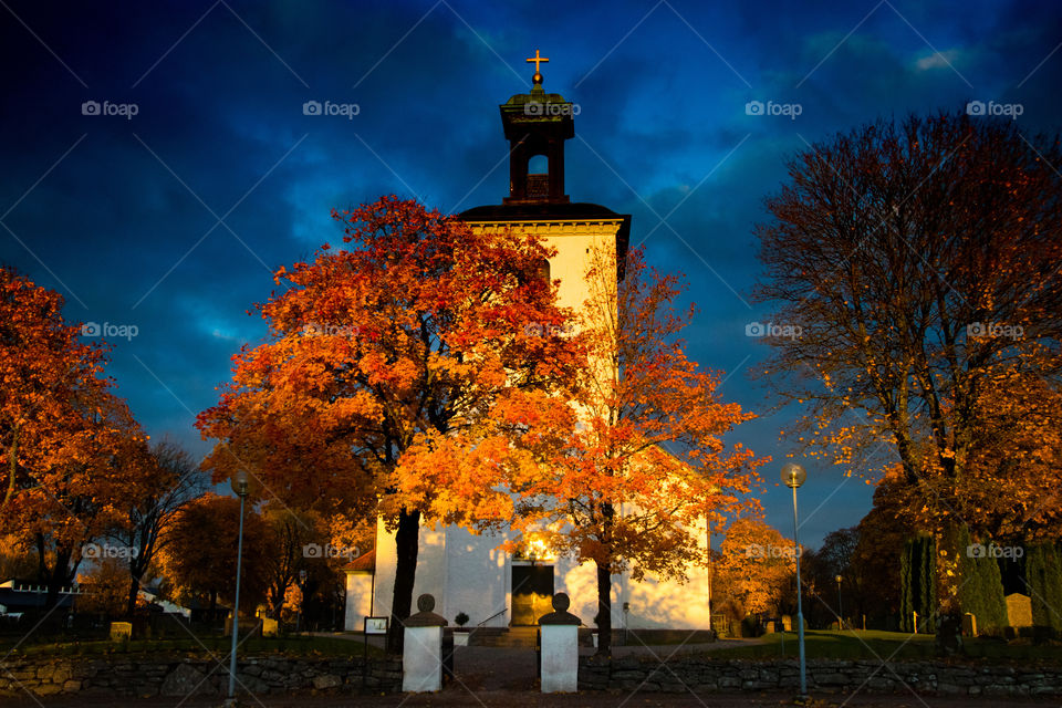 Swedish church in the glow of a beautiful sunset surrounded by autumn colours