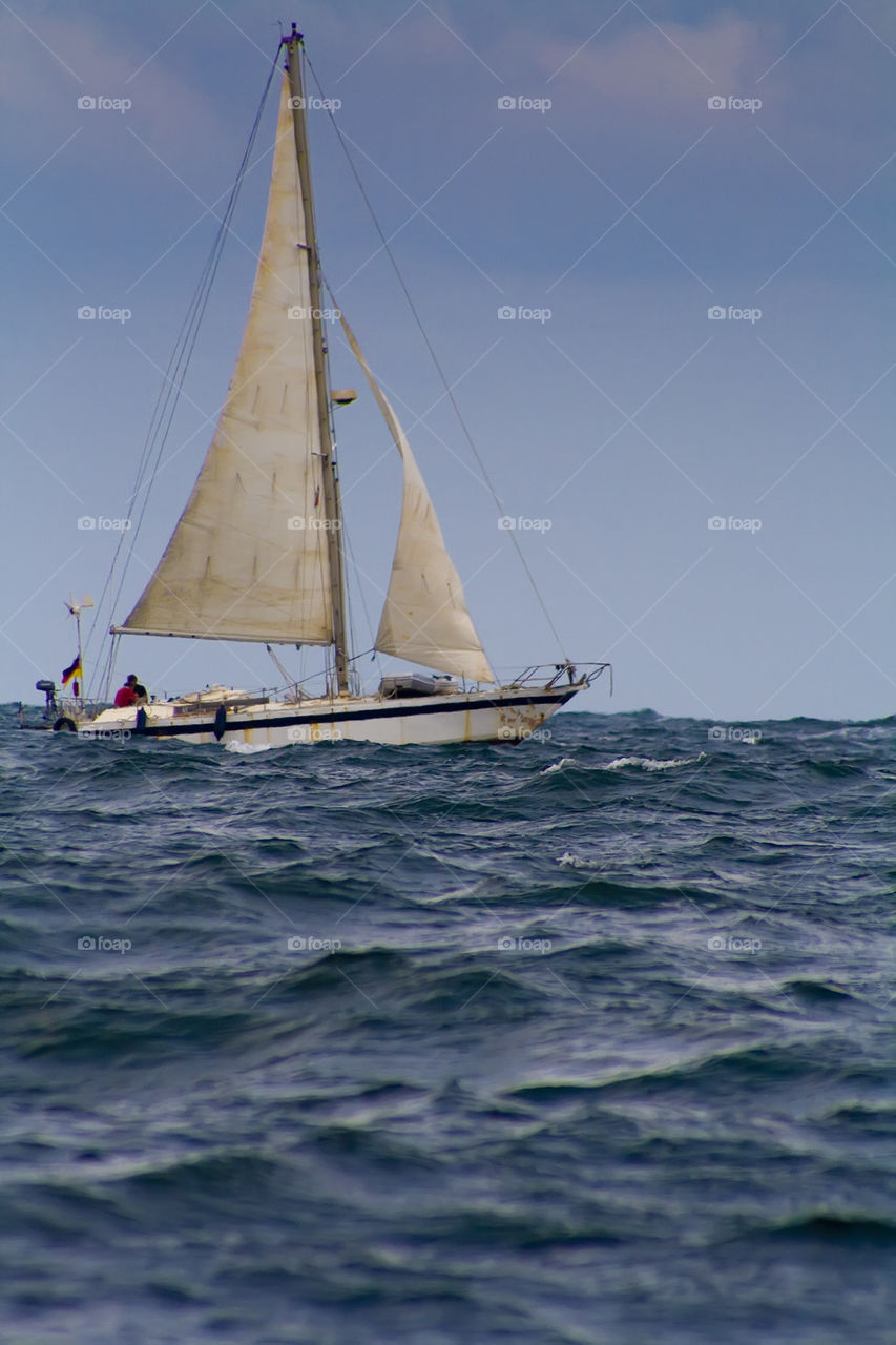 White yacht in blue waves