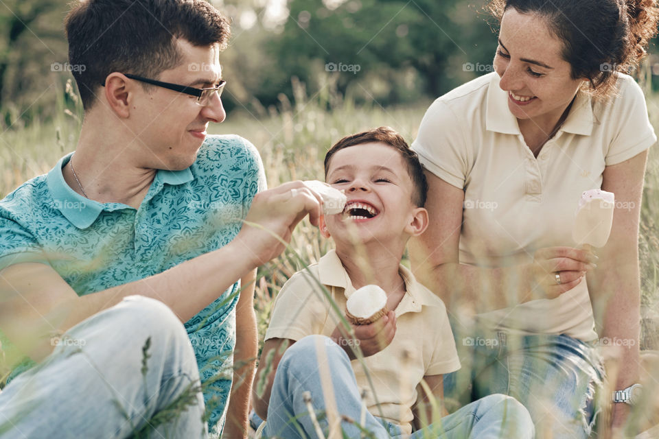 Happy laughing family eating ice cream on a picnic