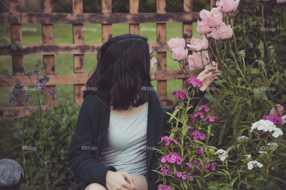 A girl enjoying natural flowers in a garden