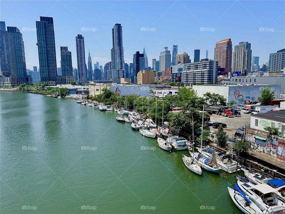 This spectacular display of maritime beauty presents itself overlooking “Newtown Creek” from the “Pulaski Bridge” that connects “Greenpoint”, Bklyn to LIC. In the distance we see “Manhattan” and the “Empire State Building”. 2024. Hypnotic Productions