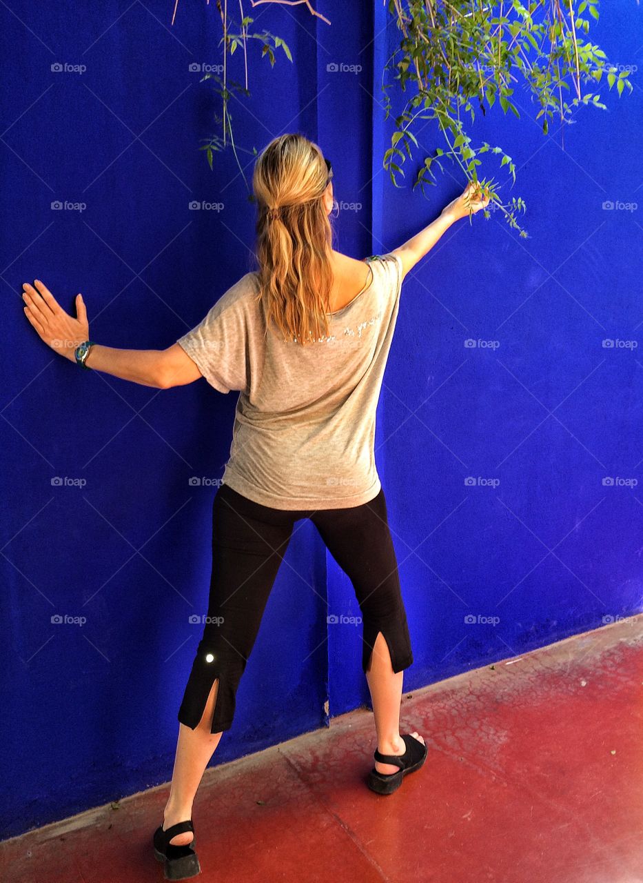 Girl posing by blue wall