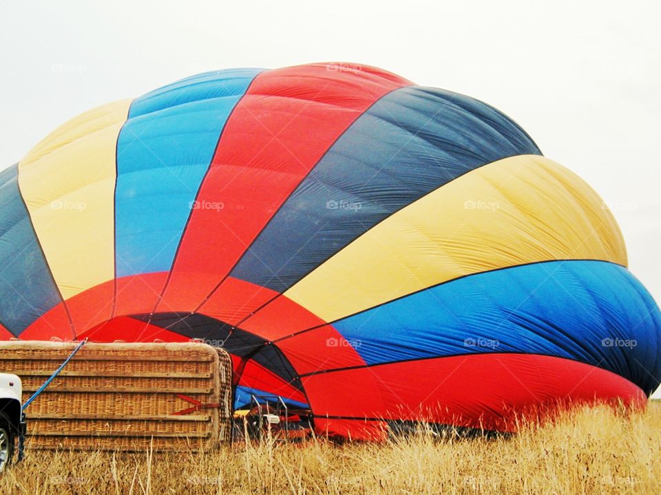 Hot air ballon and basket. A hot air balloon nearly inflated with a large wicker basket 