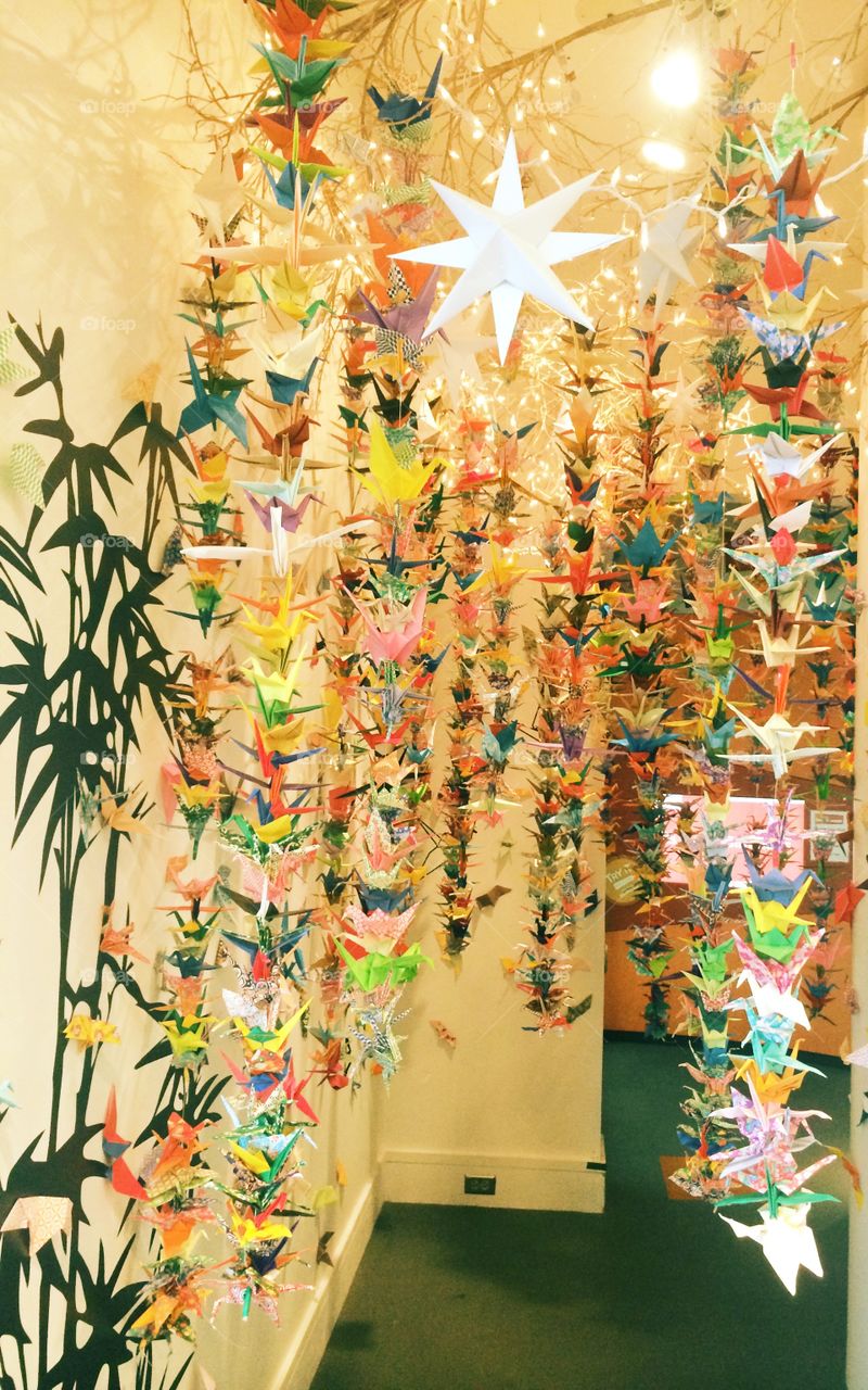 Pastel art installation with origami birds in museum