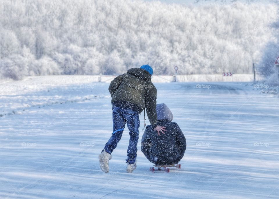 With skateboard in snow