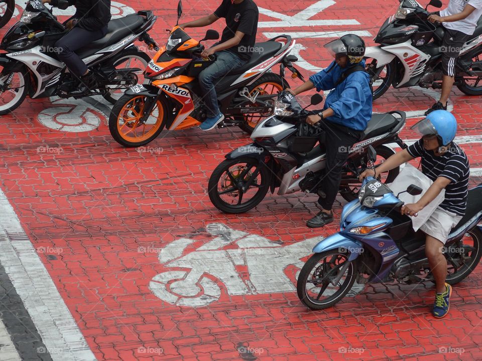 High level view of motorcyclist at the traffic lights in the city of Kuala Lumpur