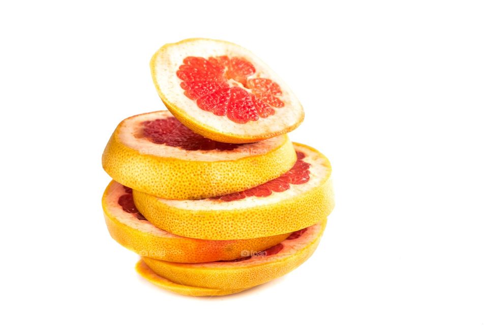 Slices of grapefruit sliced on white isolated background.