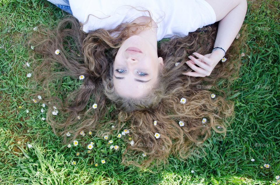 Portrait of a Beautiful Young Girl on Background of Daisies