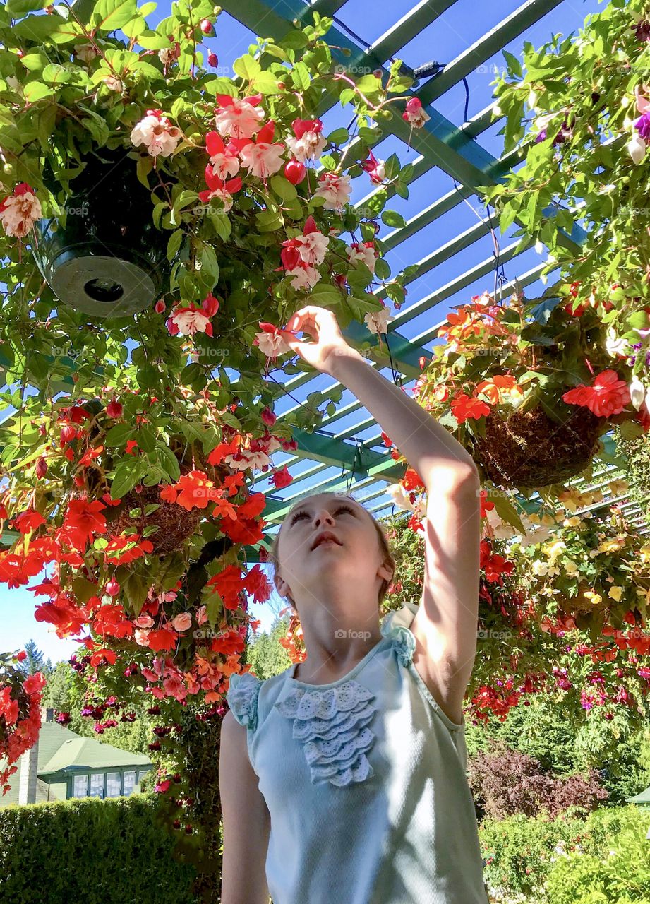 Girl surrounded by bright hanging flowers