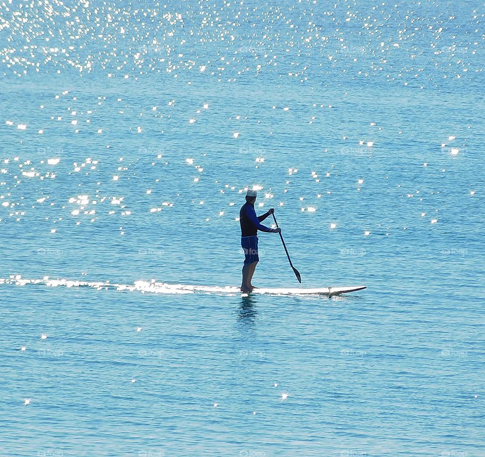 Paddle boarding across the shimmering bay