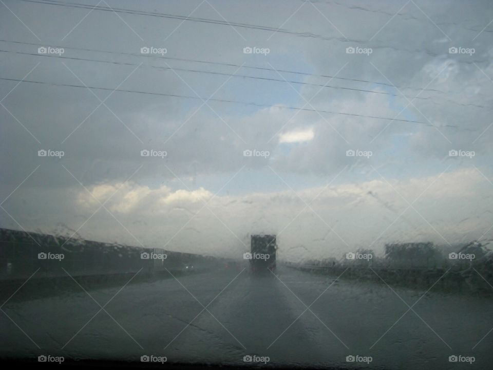 Driving in a heavy rain with a lorry on horizon 