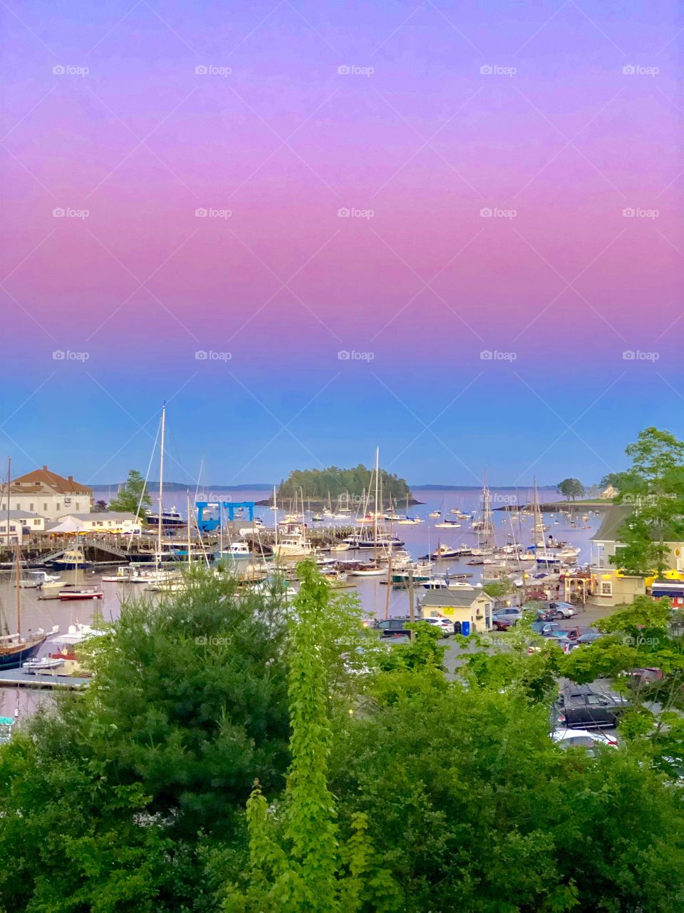 Pastel Sunset over Camden Harbor in Maine during summer season as viewed from rooftop deck of Camden Deli.