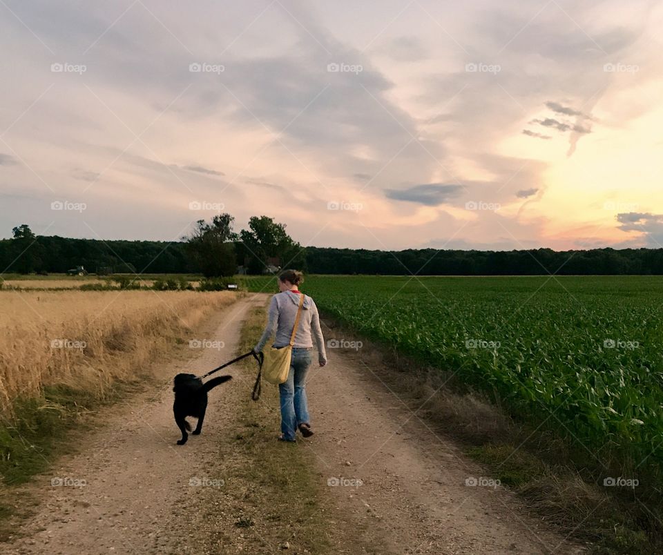 Woman Walking Dog on Dirt Road