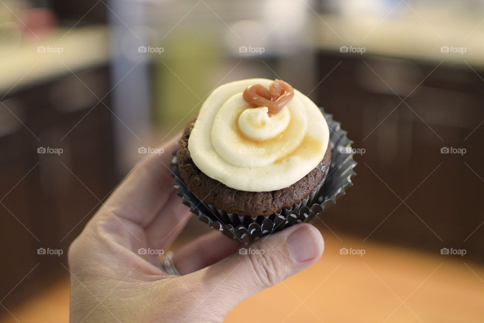 Hand holding a cupcake in the kitchen 