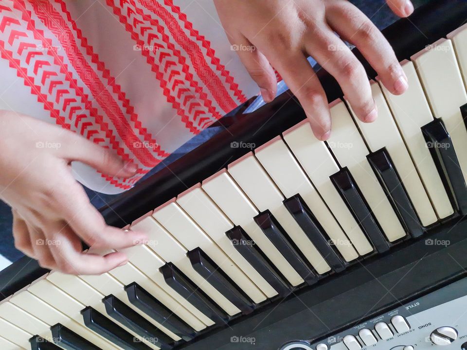 A kid playing an instrument - Keyboard