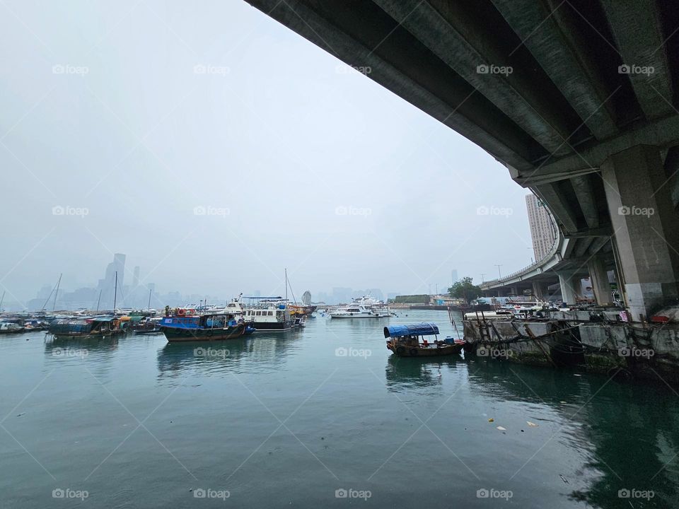 boats under and by the bridge at the typhoon shelter