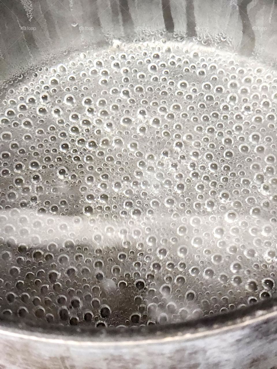 small bubbles in boiling hot water in a metal pot