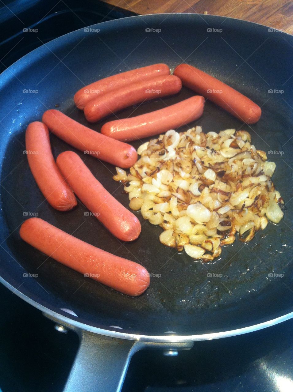 Frying hotdogs and onions