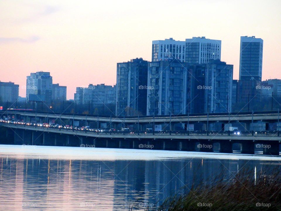 evening blue over the river in the city of Voronezh, Russia, the double-decker bridge is filled with cars