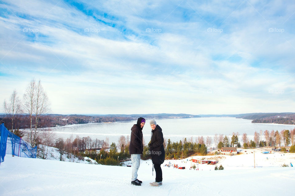 Two friends on top of a snowy hill