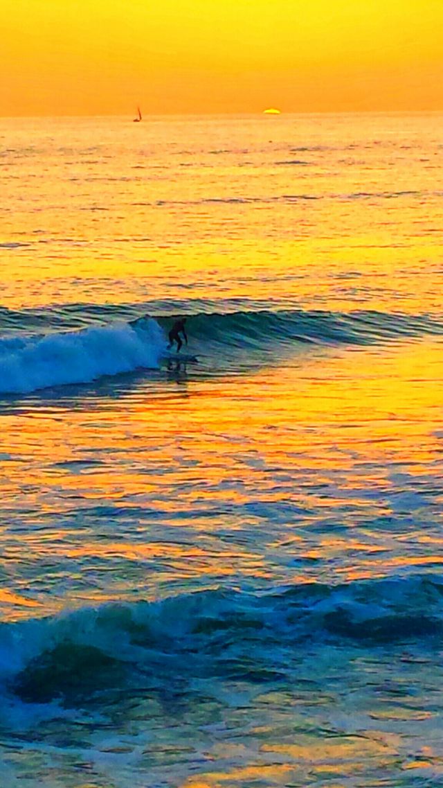 Surfer @ Sunset. Surfer enjoing the waves @ beautiful orange sunset in Laguna Beach.
