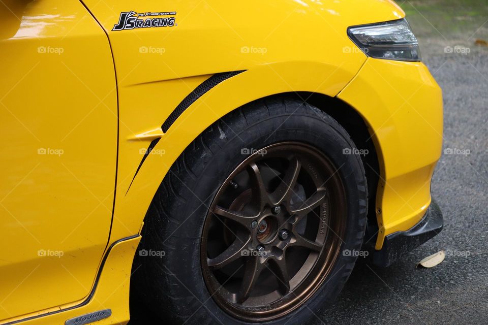 Yellow car with black tyre in close up view