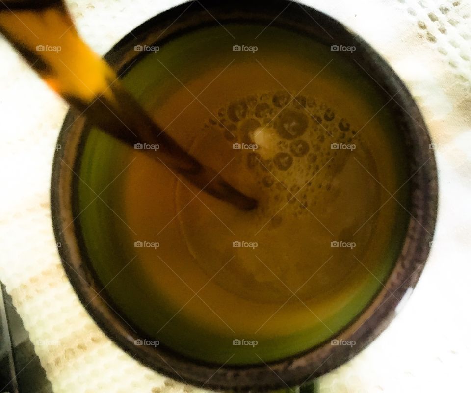 Pouring coffee into green and yellow coffee mug 
