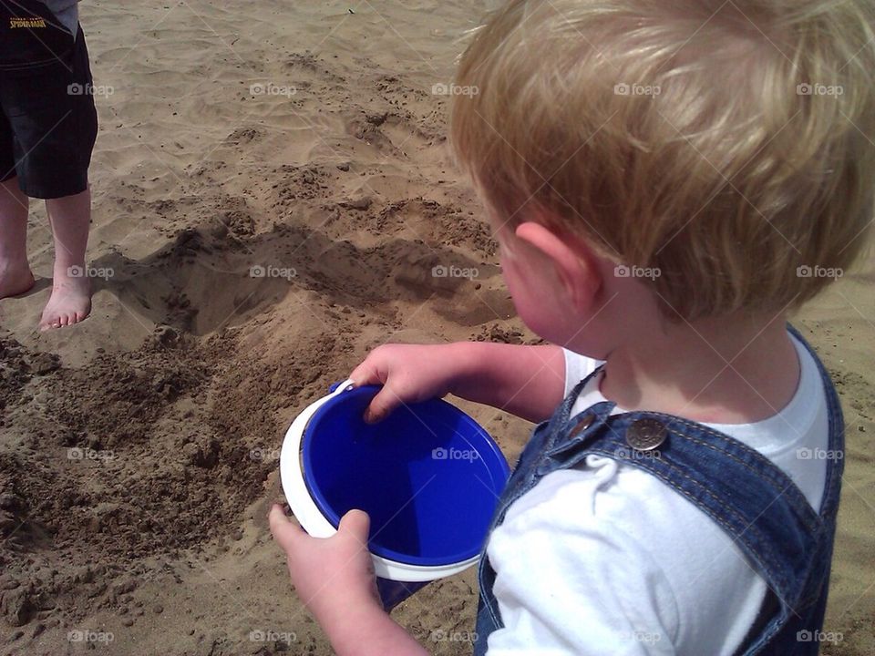 Bucket with child on beach