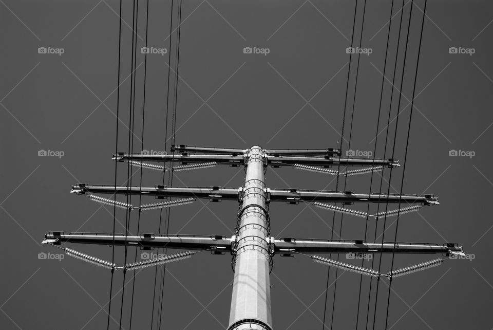 Black and white 90 degree true vertical angle of a steel high tension power tower.