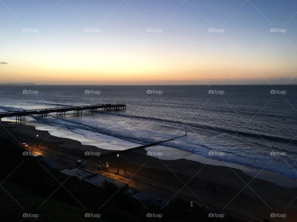 Boscombe Pier on an early winter morning with the sun rising and the waves coming in like mirrors