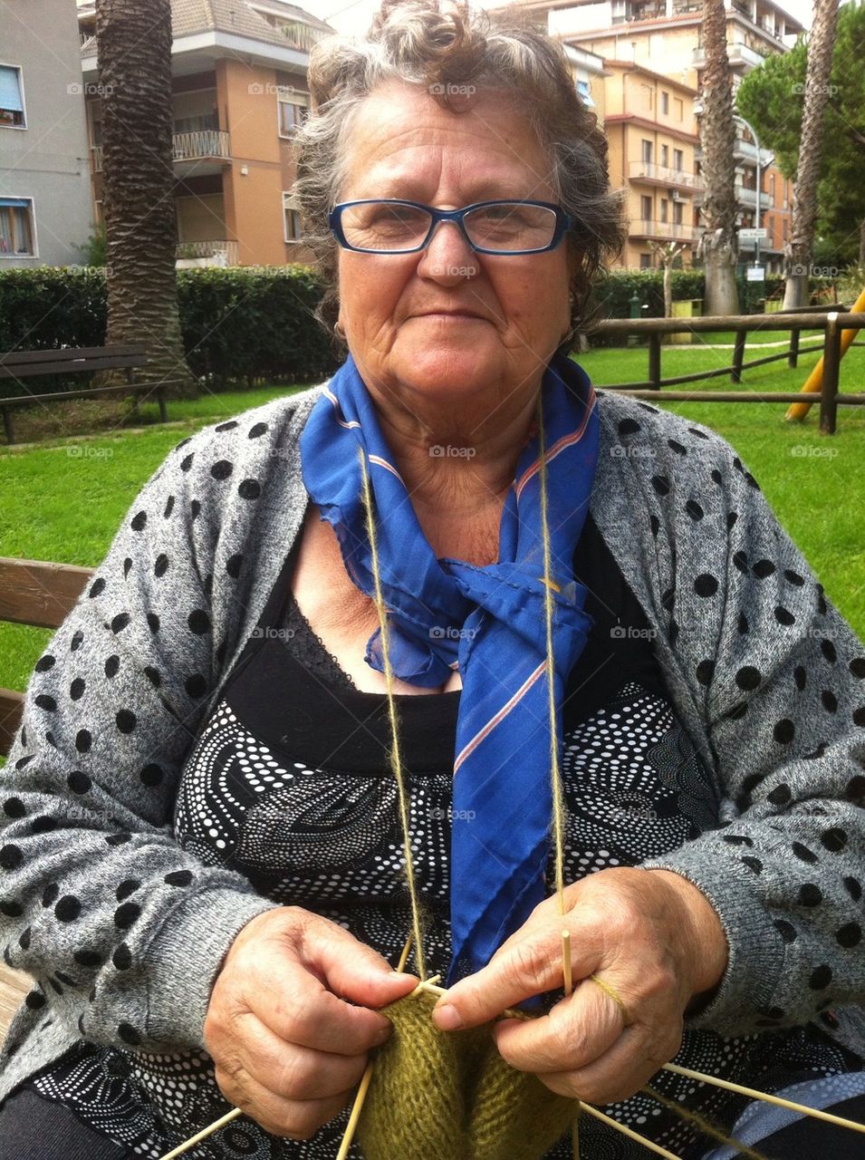 Grandmother knitting on a bench