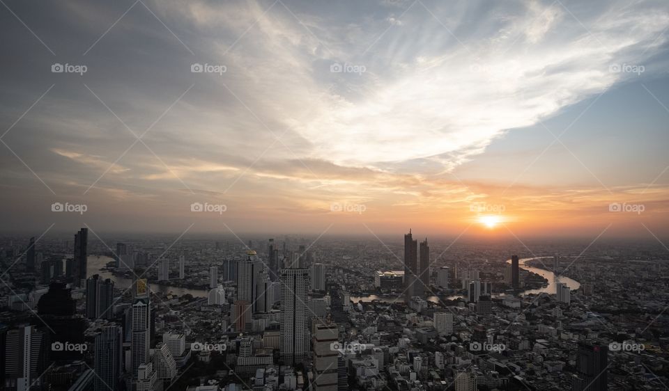 Beautiful sunset scene over skyscraper in the capital city , Bangkok Thailand roof top Mahanakorn Building 