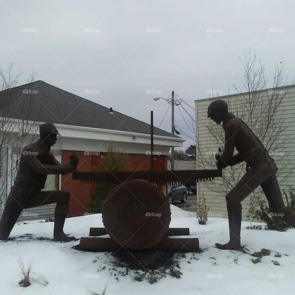 Statue of two men sawing a log in Downtown Shawano, Wisconsin.