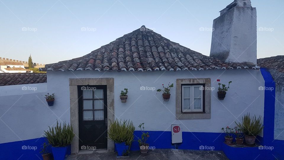 Traditional tiny house painted in blue and white at Obidos, Portugal