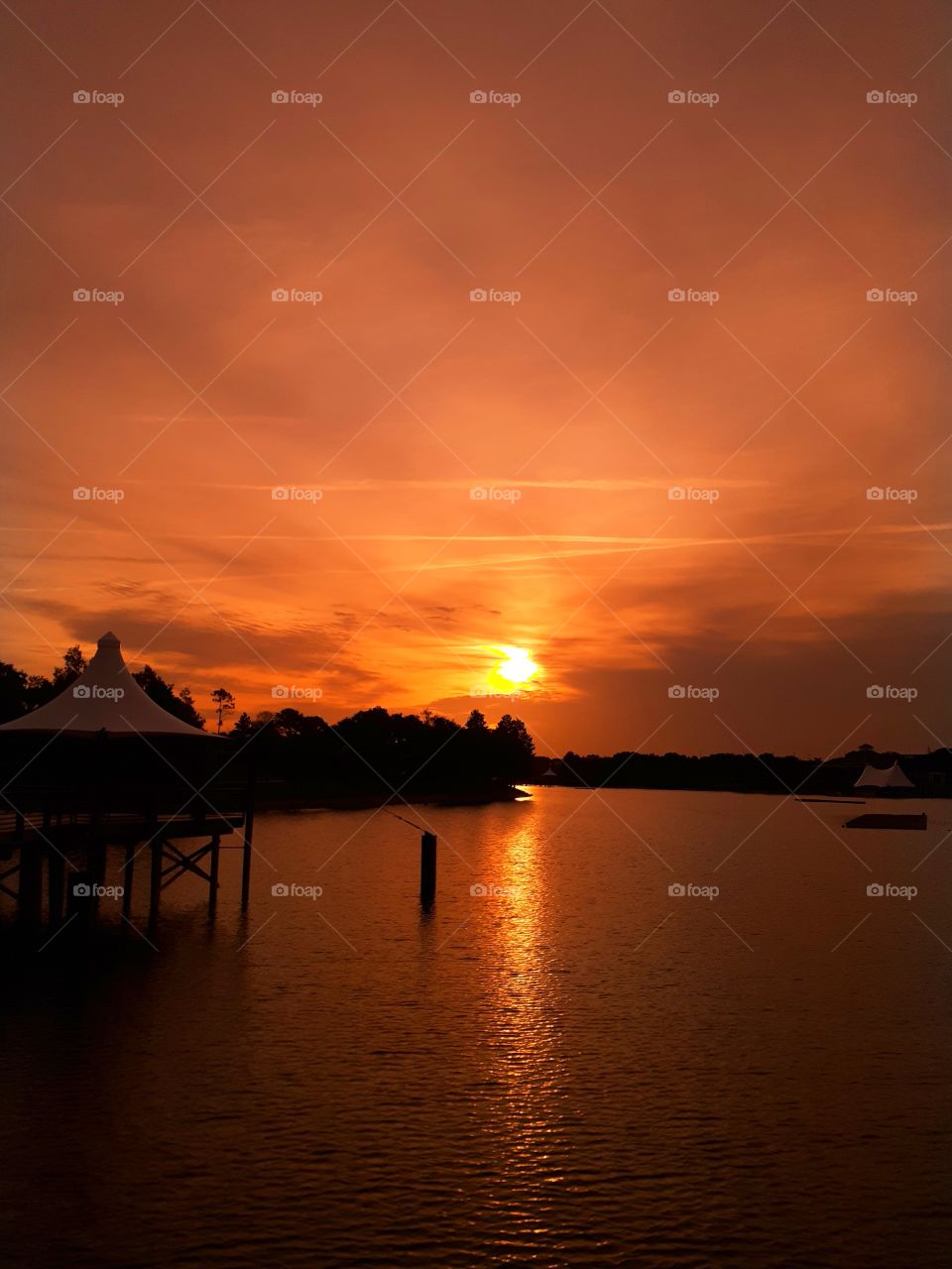 A beautiful orange sunrise over the lake at Cranes Roost Park in Altamonte Springs Florida.