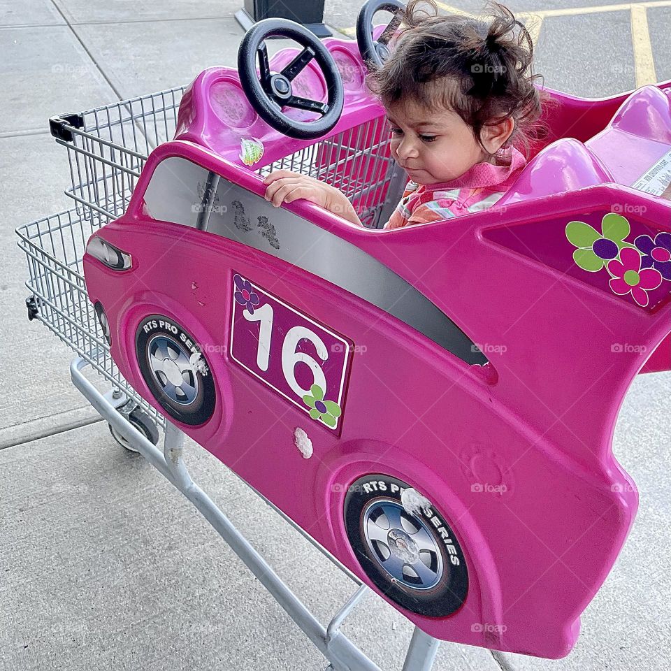 Toddler rides in Barbie Style car cart at the store, Barbie style race car for children, pink car and pink clothes, all pink style 