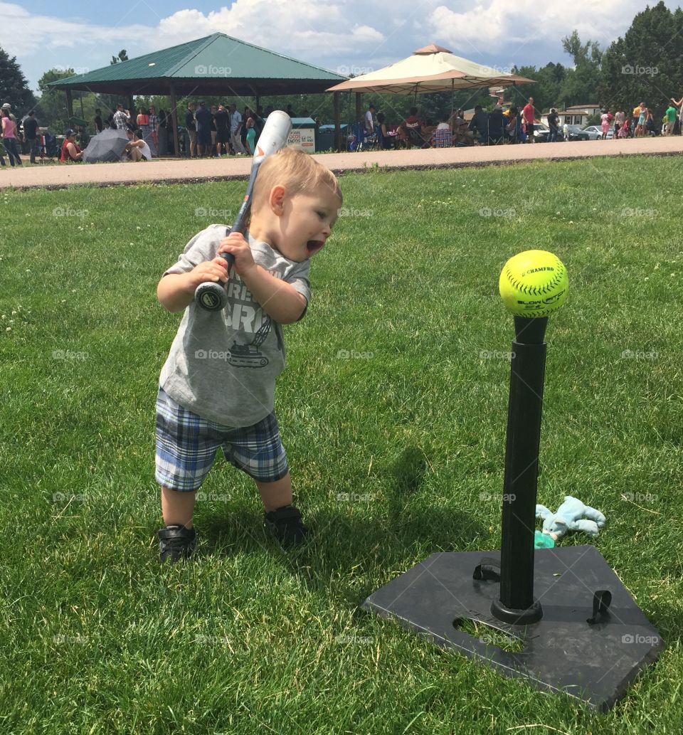 Little boy playing with stick and baseball
