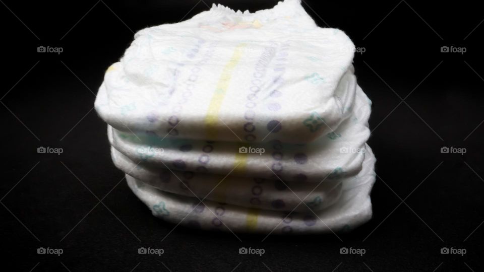 Baby diapers stacked each other on isolated background.
