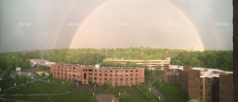 Double rainbows formed over a campus after a storm